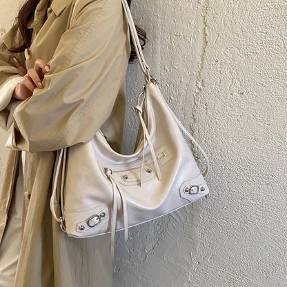 Slouchy shoulder bag with front zip and buckle details — cream worn over beige coat | BTendance