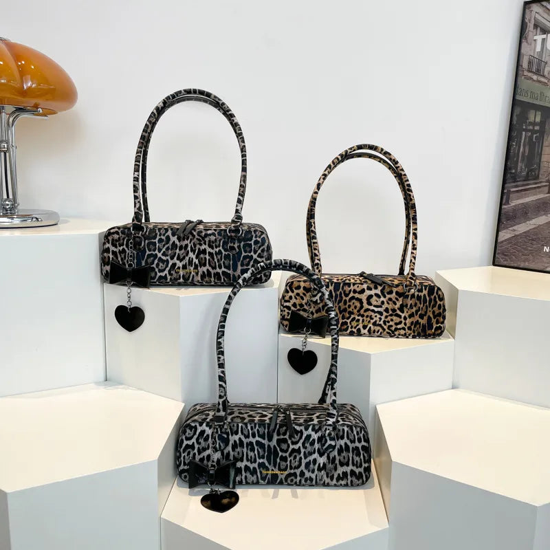 Leopard print shoulder bag with heart charm – Three leopard print bags on display blocks | BTendance