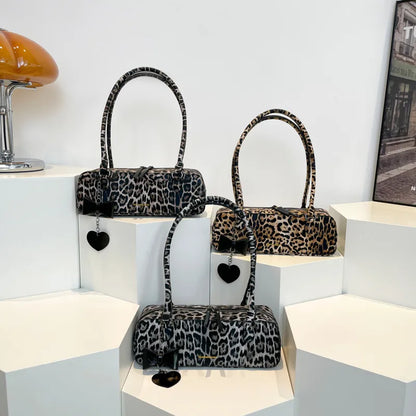 Leopard print shoulder bag with heart charm – Three leopard print bags on display blocks | BTendance