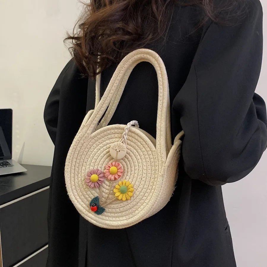 Round woven handbag with flower decoration – Cream flower bag worn with a black outfit | BTendance