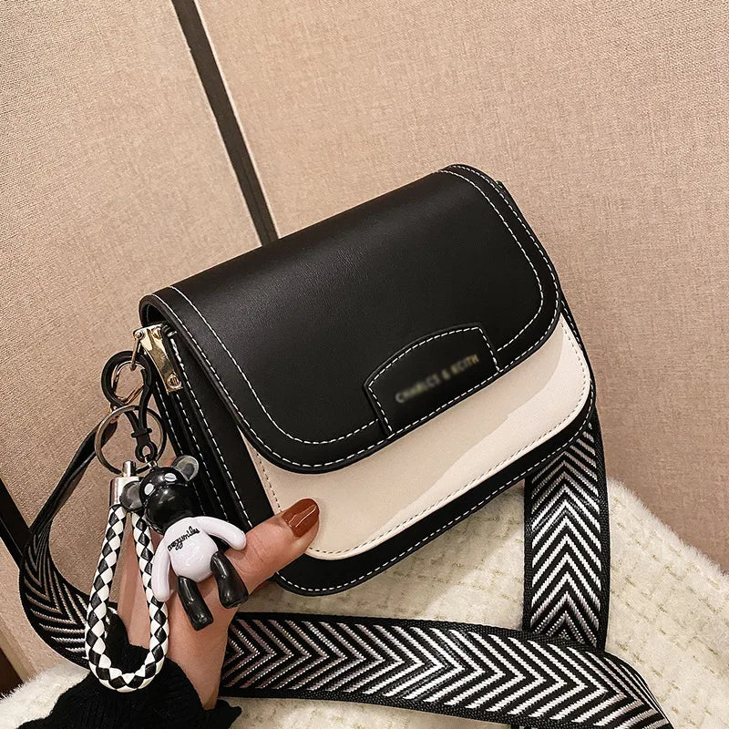 Colour block crossbody bag with patterned strap – Black and cream bag held in one hand | BTendance