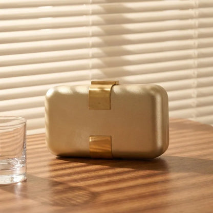 Rectangular evening clutch — gold front view on wooden cabinet | BTendance
