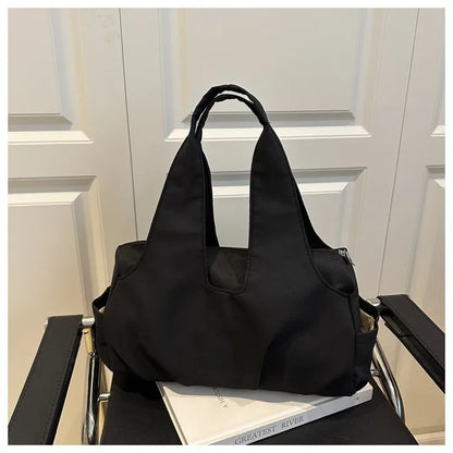 Soft shoulder tote with wide handles and side pockets — black on chair | BTendance