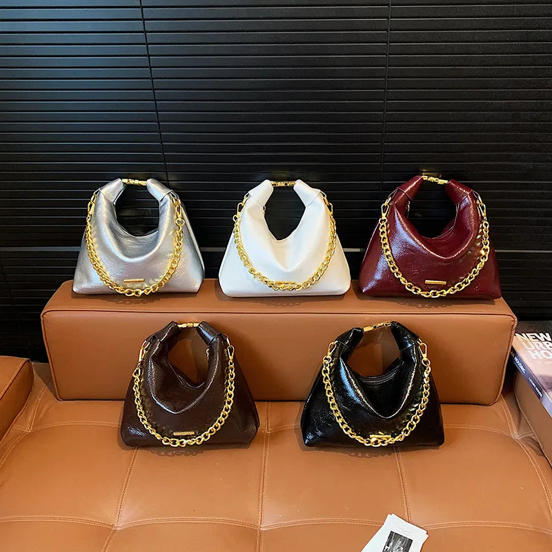 Soft handbag with gold tone chain – Five colour bags arranged on a sofa | BTendance
