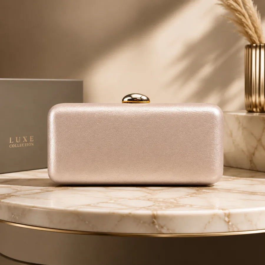 Rectangular evening clutch with oval metal clasp — champagne on marble display | BTendance