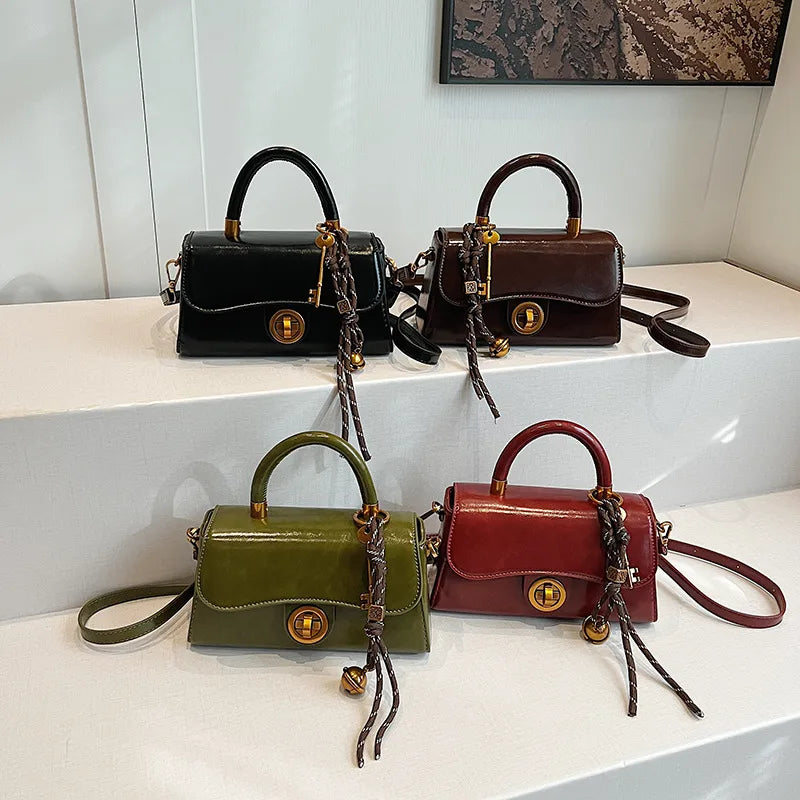 Structured top-handle flap handbag with round gold-tone clasp — four colors grouped on display | BTendance