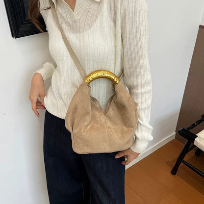 Suede-look bucket handbag with curved gold-tone handle — beige worn crossbody | BTendance