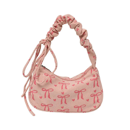 Bow-print corduroy shoulder bag with gathered handle — pink front view on white background | BTendance
