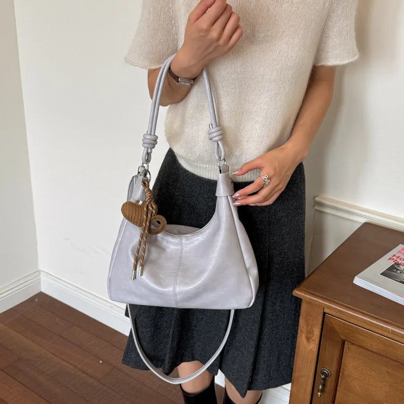Slouchy shoulder bag with knotted strap and hanging charm — silver worn on shoulder | BTendance