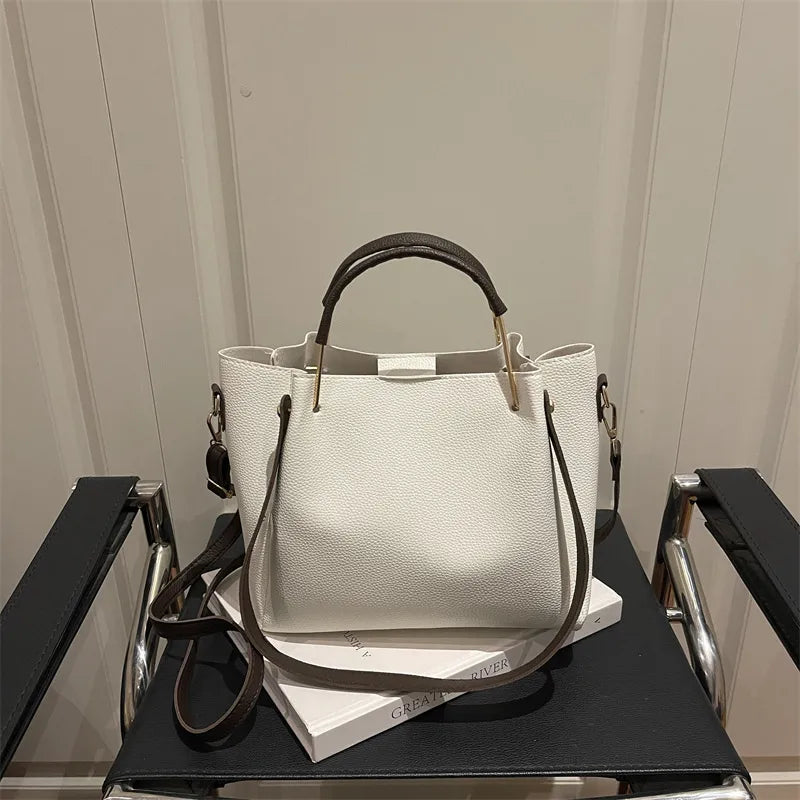 Textured bucket handbag with contrasting dark handles — white on chair | BTendance