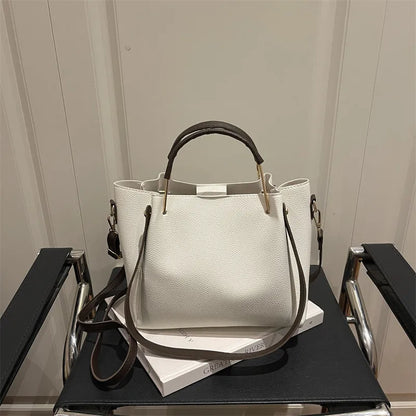 Textured bucket handbag with contrasting dark handles — white on chair | BTendance