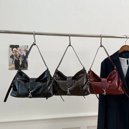 Glossy shoulder bag with central strap and metal clip — black brown and burgundy hanging together | BTendance