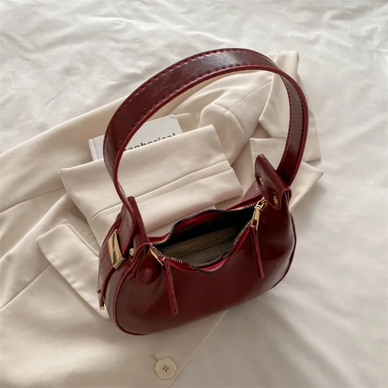 Curved zip shoulder bag – Burgundy bag opened to show the interior | BTendance