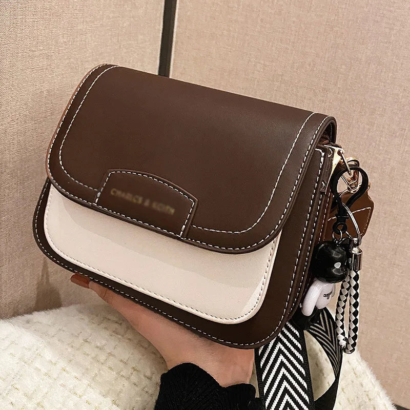 Colour block crossbody bag with patterned strap – Brown and cream bag held in one hand | BTendance