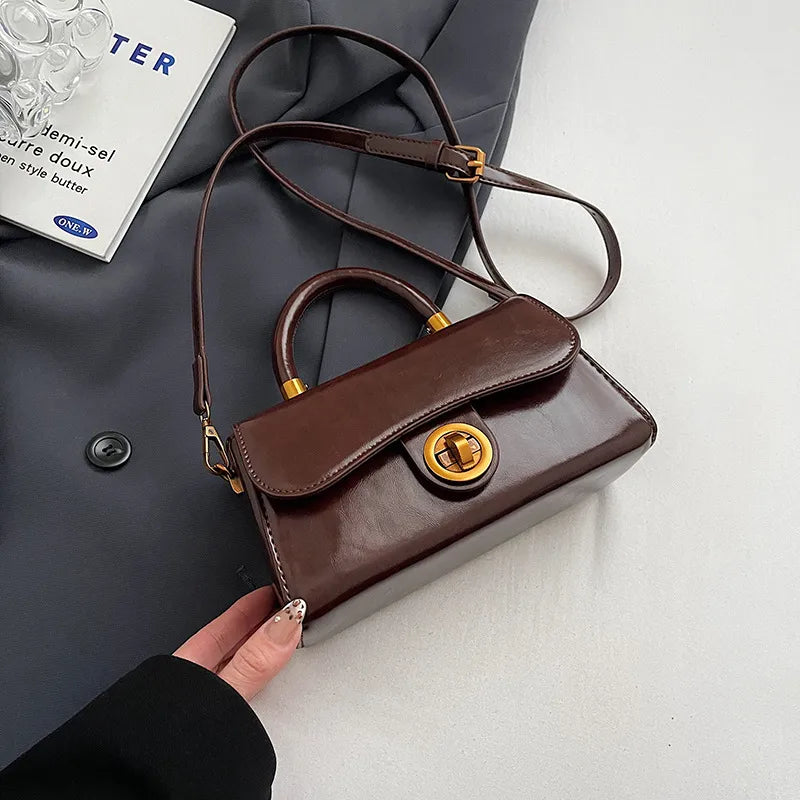 Structured top-handle flap handbag with round gold-tone clasp — brown with extended shoulder strap | BTendance
