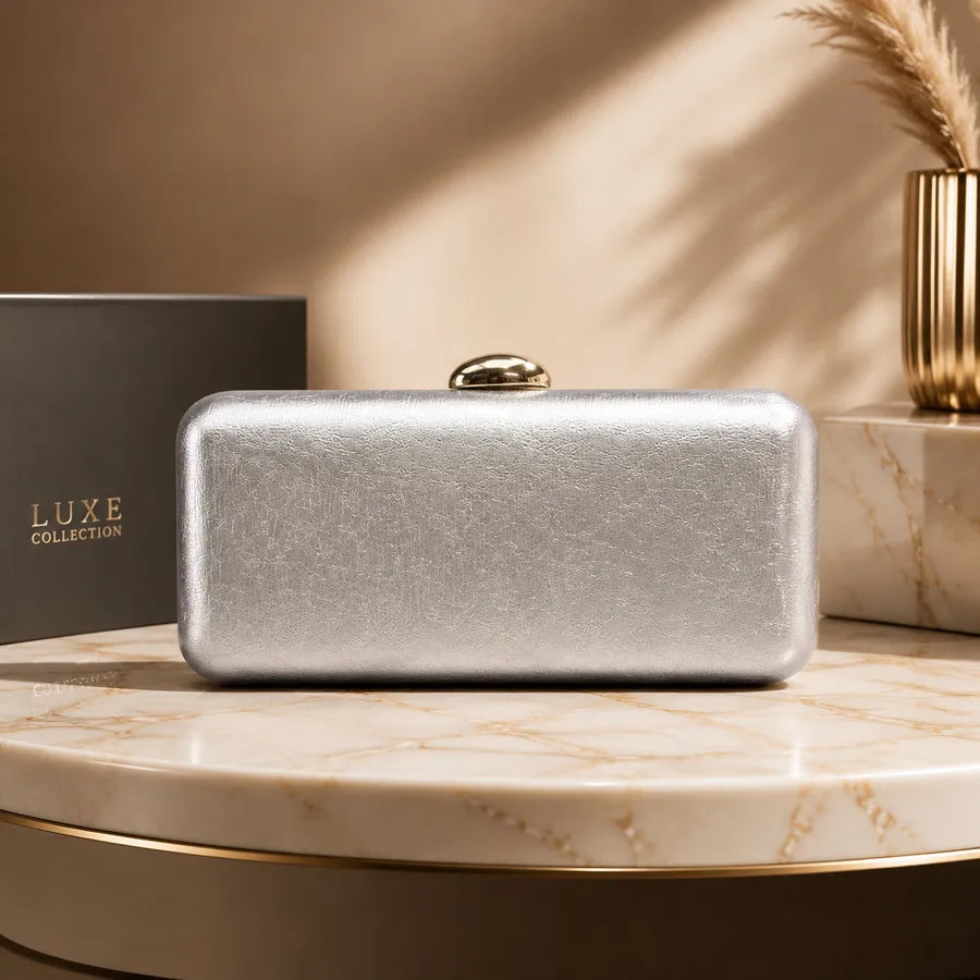 Rectangular evening clutch with oval metal clasp — silver on marble display | BTendance