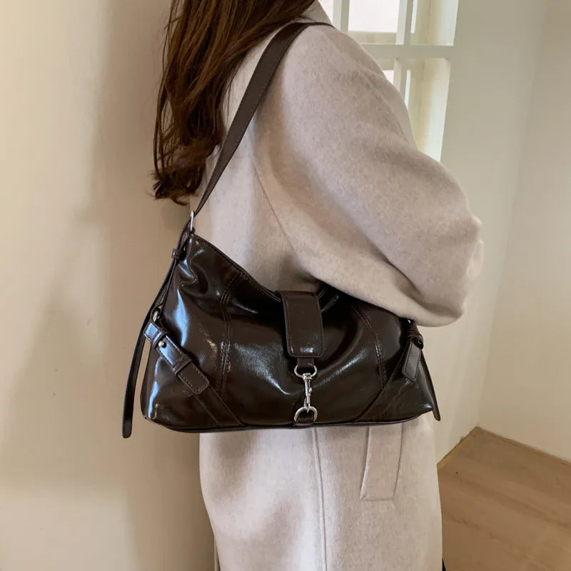 Glossy shoulder bag with central strap and metal clip — brown worn on shoulder | BTendance