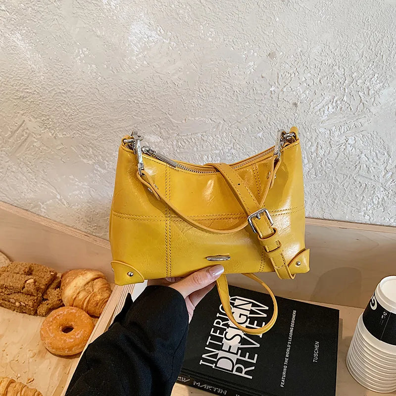 Glossy shoulder bag with strawberry charm – Yellow bag, side angle in hand | BTendance