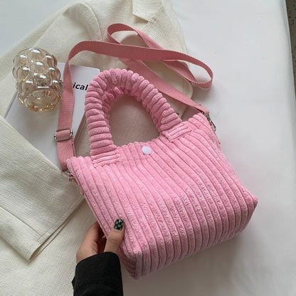 Ribbed plush handbag with rounded handles and long strap — light pink on fabric display | BTendance