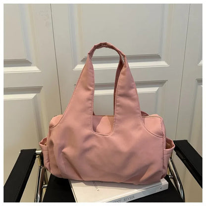 Soft shoulder tote with wide handles and side pockets — pink on chair | BTendance