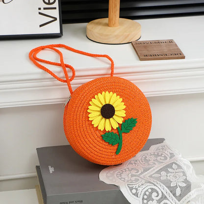 Round woven sunflower crossbody bag – Orange stem and leaf sunflower bag on a display table | BTendance