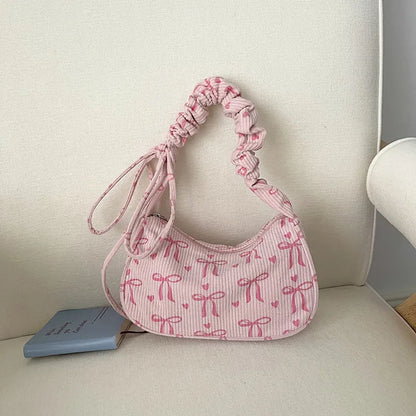 Bow-print corduroy shoulder bag with gathered handle — pink on cream chair | BTendance
