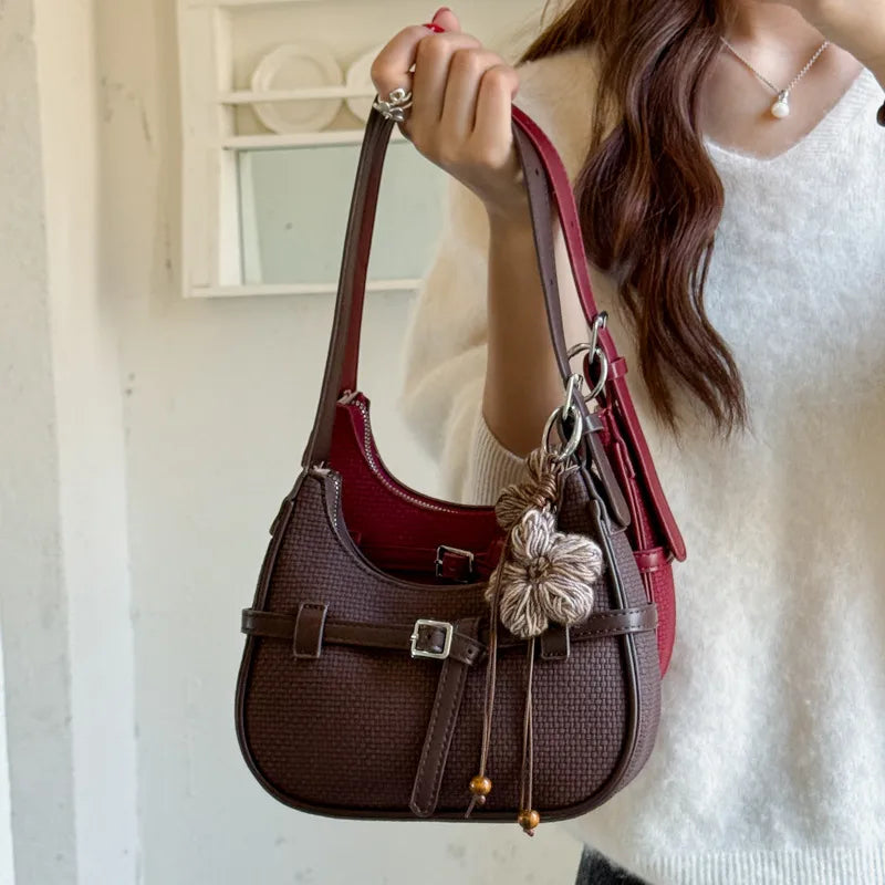 Buckle shoulder bag with floral charm – Brown bag held beside a white outfit | BTendance