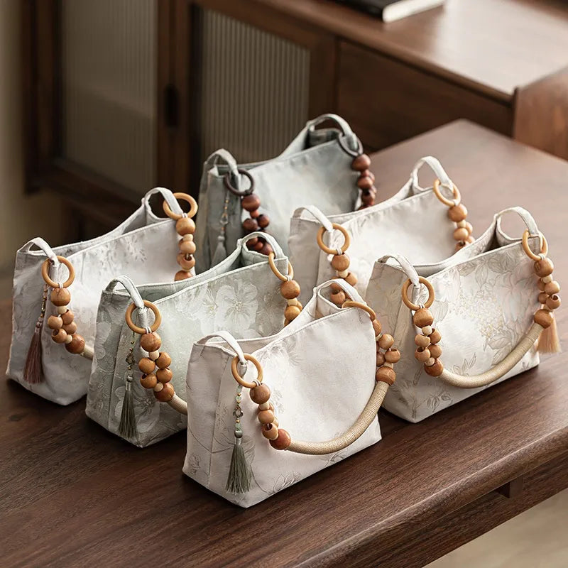 Floral shoulder bag with beaded handle – Assorted pale colours arranged on a table | BTendance