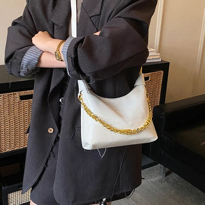 Soft handbag with gold tone chain – White bag carried with a dark jacket | BTendance
