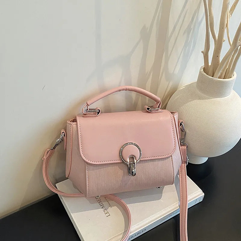 Ring clasp top handle crossbody bag – Pink bag beside a vase | BTendance