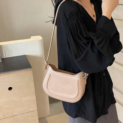 Curved shoulder bag with outlined front panel and knotted strap — cream worn on shoulder | BTendance