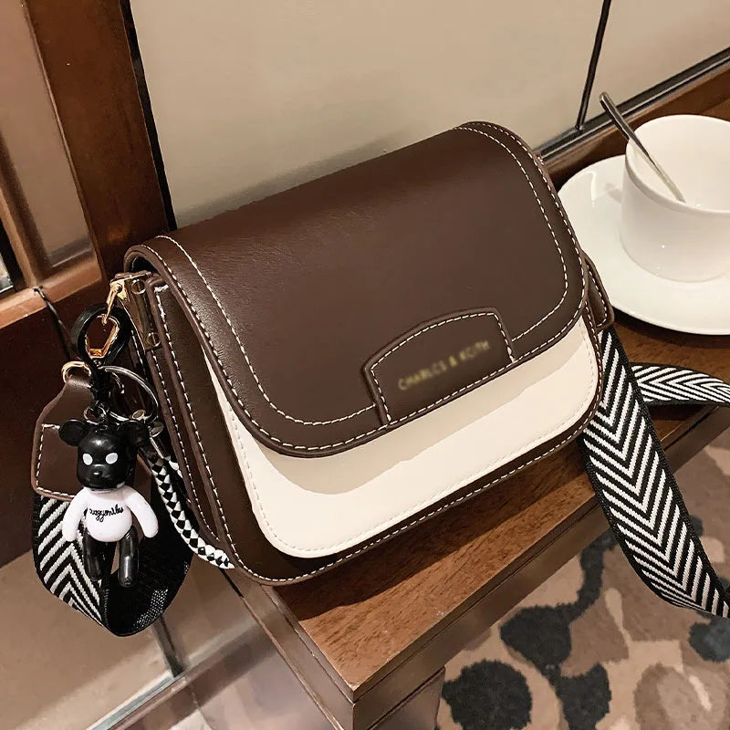 Colour block crossbody bag with patterned strap – Brown and cream bag on a table | BTendance