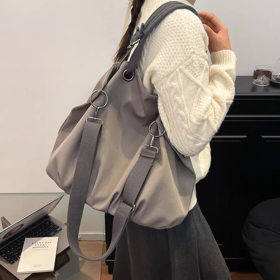 Slouchy nylon shoulder bag with contrasting grey handles — grey worn over cream sweater | BTendance