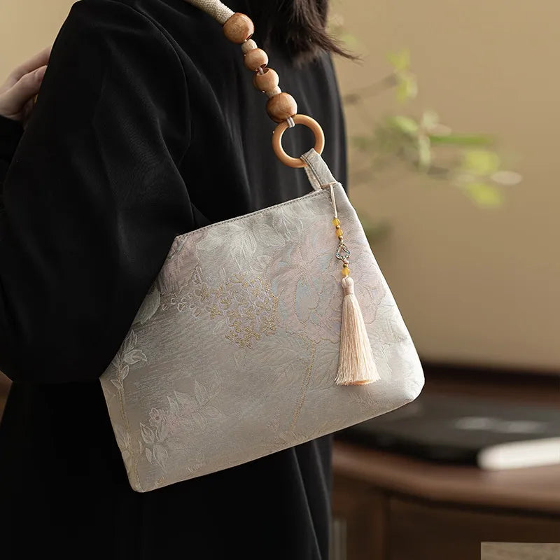 Floral shoulder bag with beaded handle – Pale patterned bag with cream tassel, worn on shoulder | BTendance