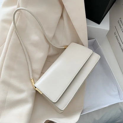 Slim rectangular flap shoulder bag with gold-tone strap accents — white on cream fabric | BTendance